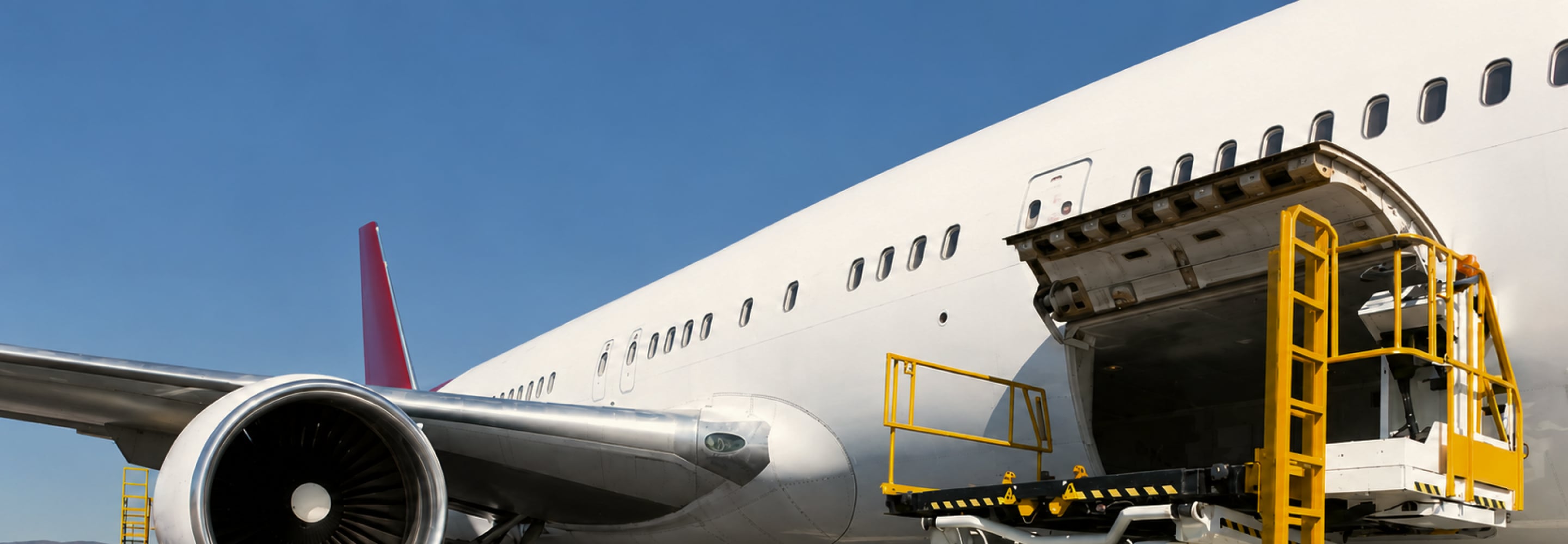 Cargo being loaded through the side door of a passenger jet, reflecting ACL Airshop's air cargo equipment and logistics services