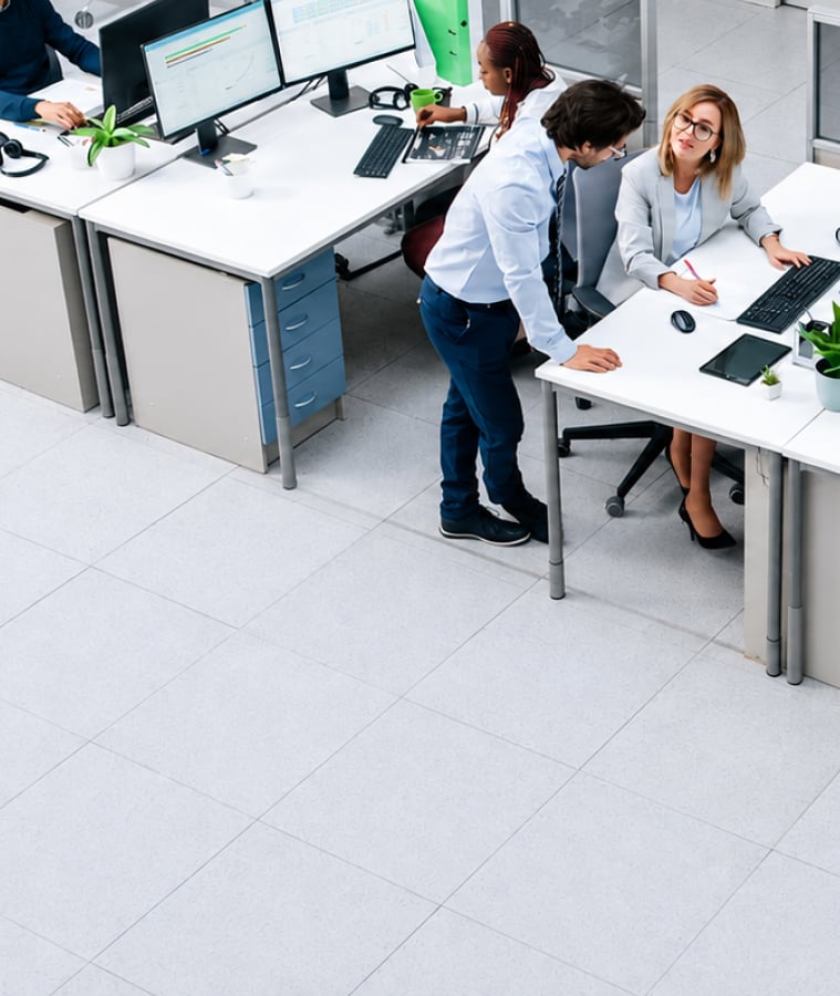 Employees working at computers in a modern open-plan office