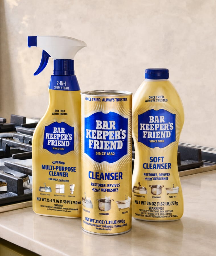 Bar Keepers Friend cleanser and multi-purpose cleaner bottles next to a stainless steel gas stove