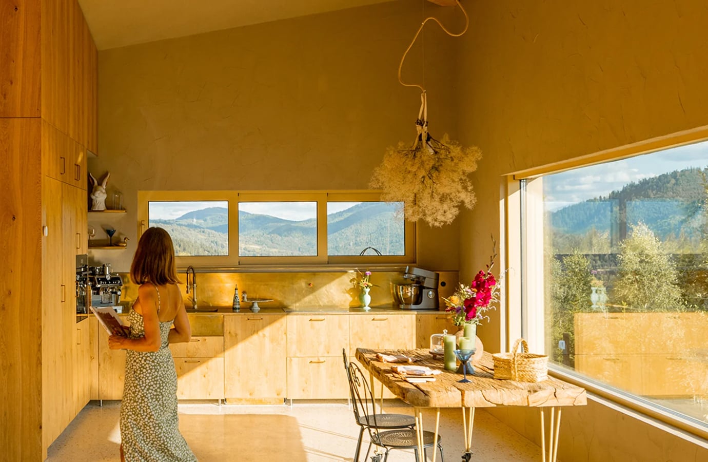 Woman in a bright, spotless kitchen with mountain views, representing Bar Keepers Friend cleaning products