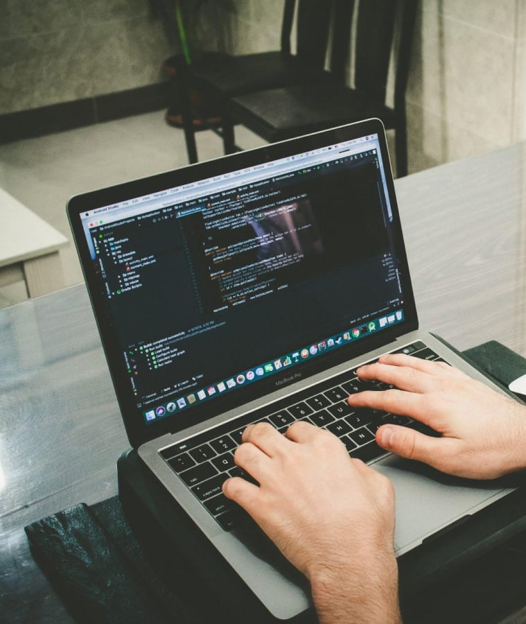 Software developer writing code on a laptop