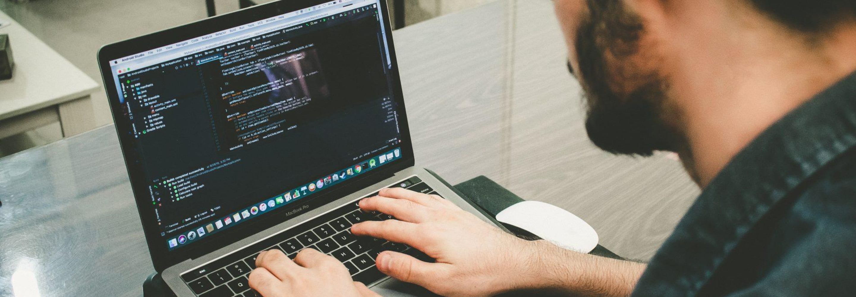 Software developer writing code on a laptop
