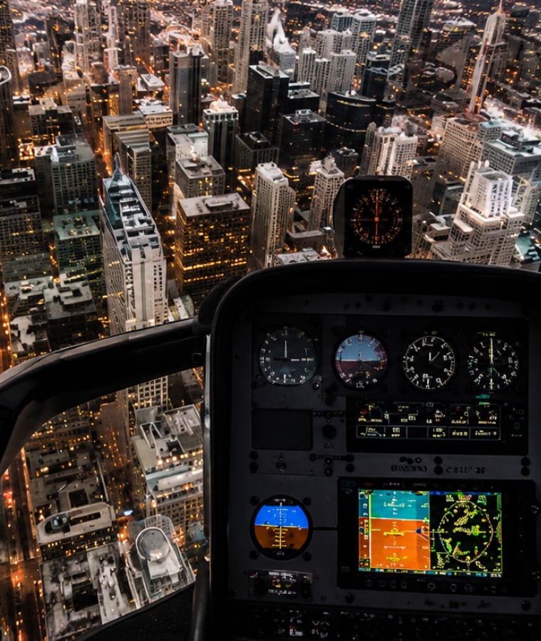 Helicopter cockpit instrument panel overlooking a city at night