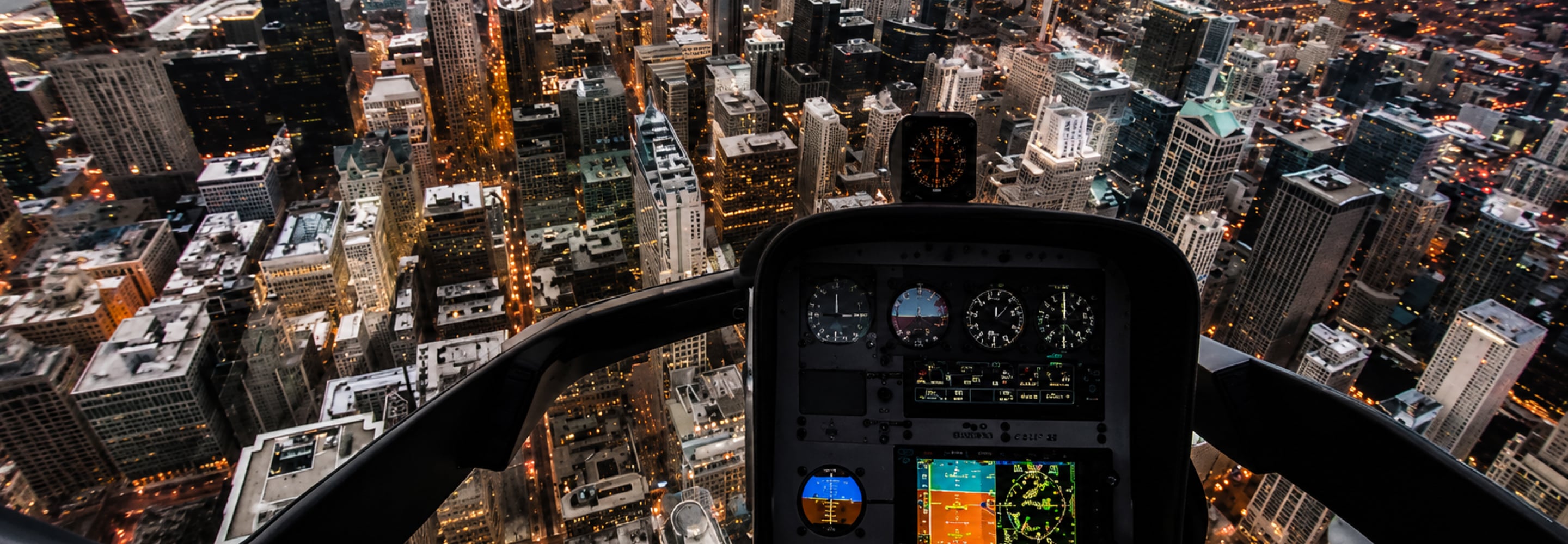 Helicopter cockpit instrument panel overlooking a city at night