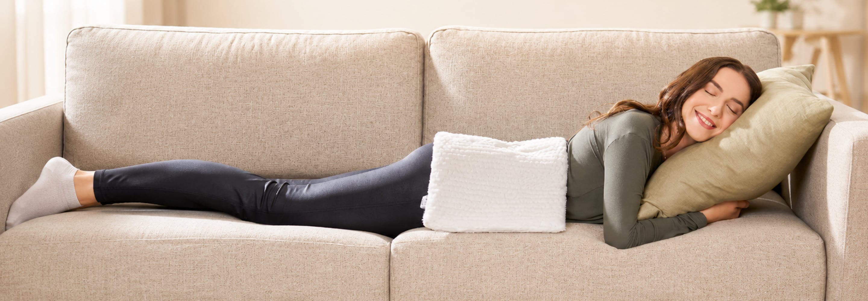 Woman resting on a couch with a pillow, recovering at home