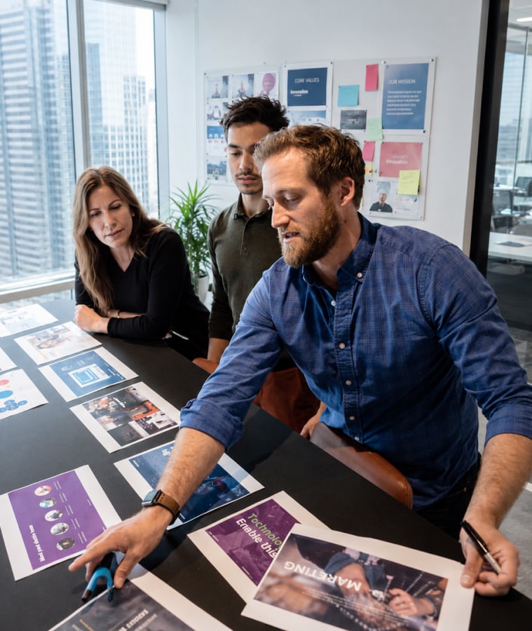 Colleagues reviewing digital marketing materials together at a table