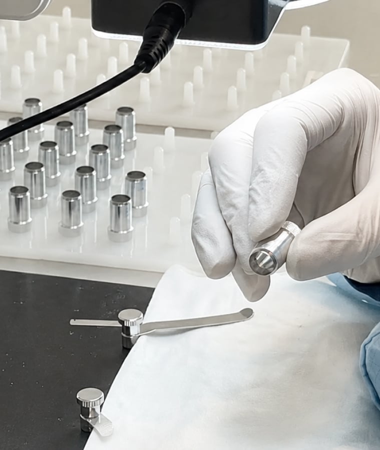 Gloved hand holding a single-use surgical instrument in a sterile setting