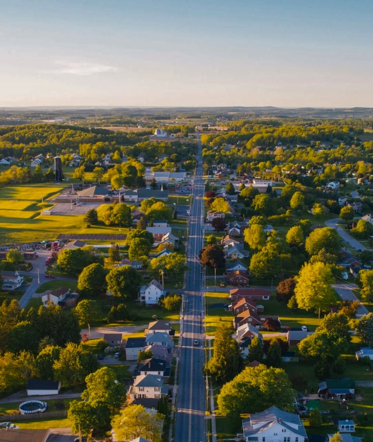 Aerial view of a small town with tree-lined streets and homes