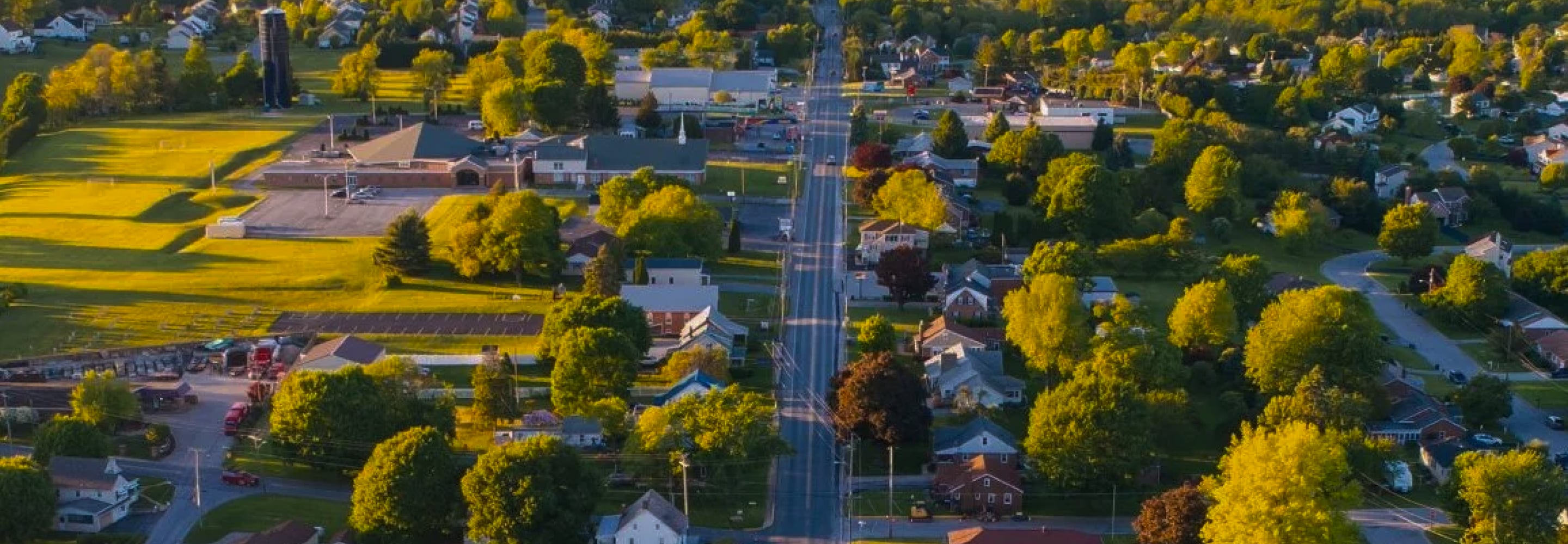 Aerial view of a small town with tree-lined streets and homes