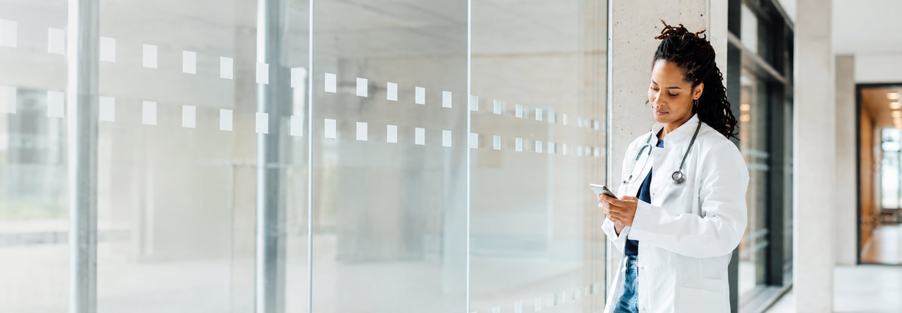 Doctor in a white coat reviewing information on a smartphone