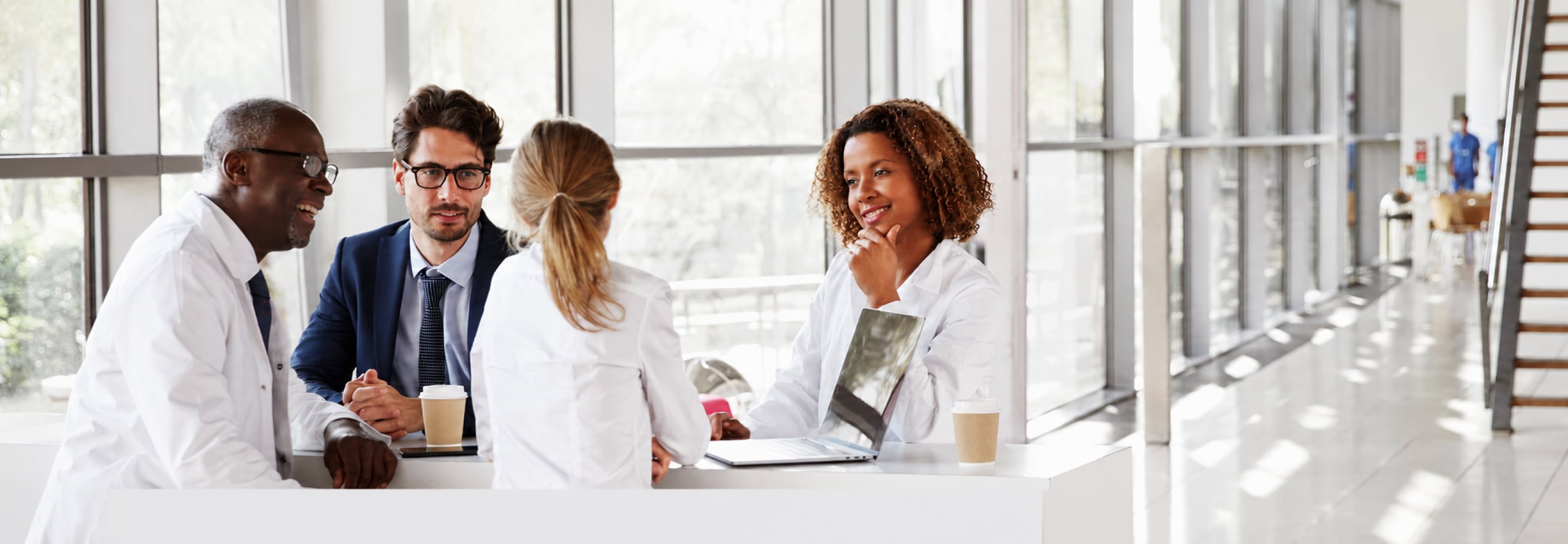 Clinical research professionals meeting around a table in a bright office
