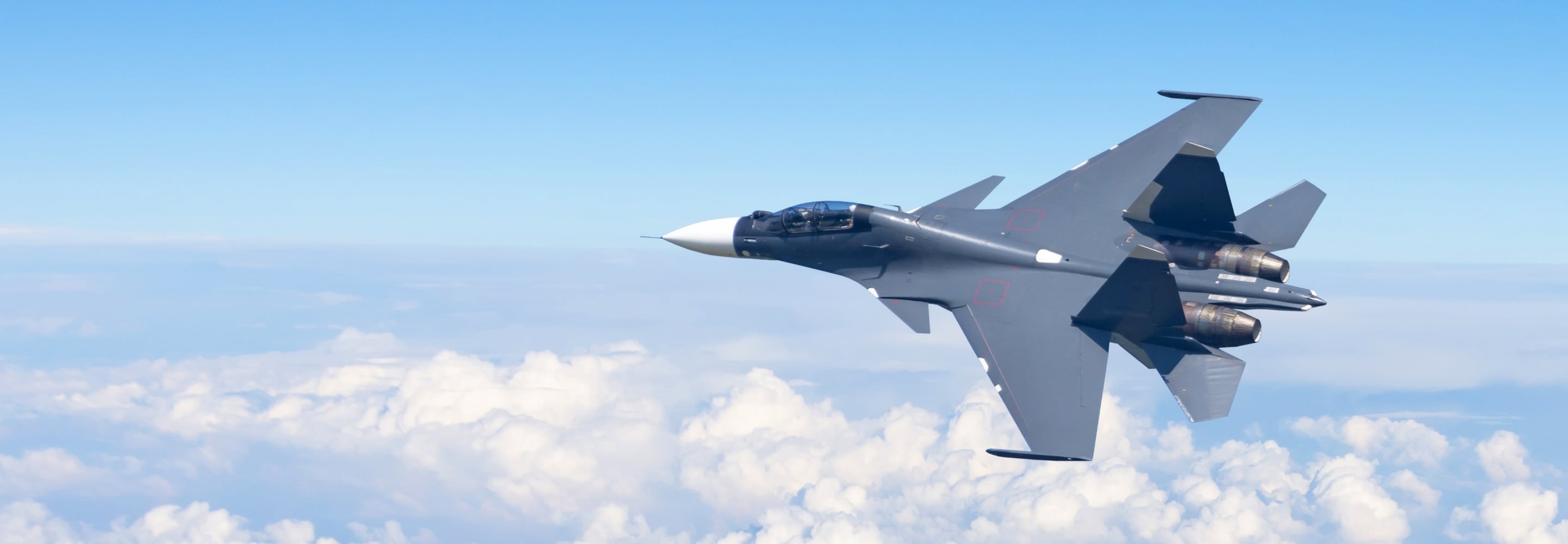 Fighter jet flying above the clouds