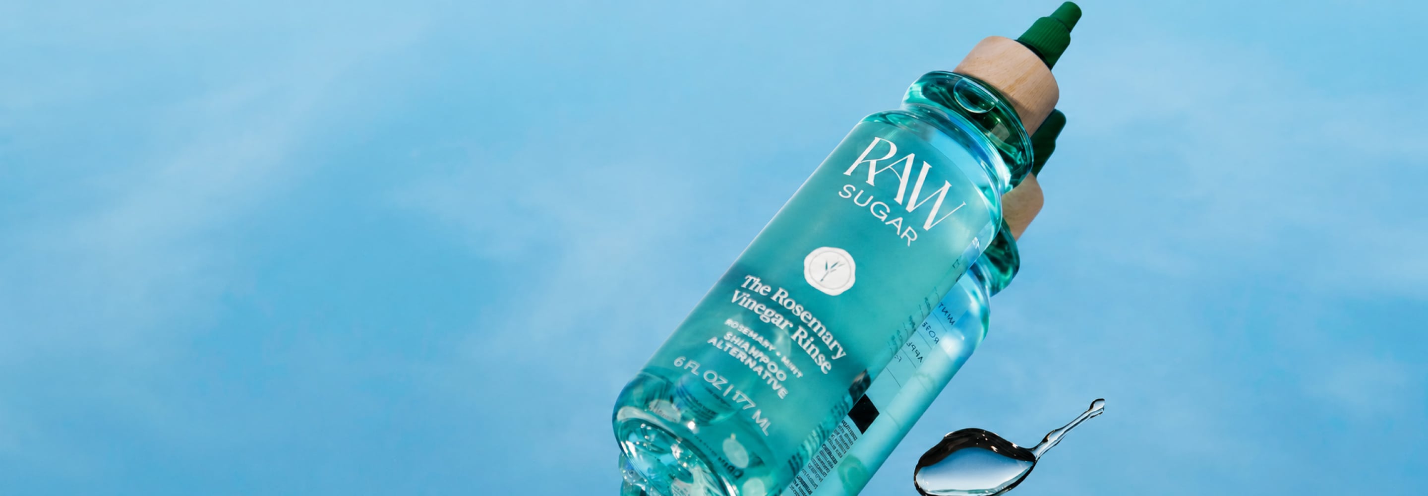 Bottle of Raw Sugar plant-based personal care product against a blue sky