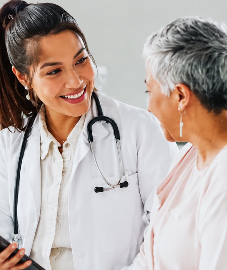 Smiling doctor with a stethoscope talking with a senior patient