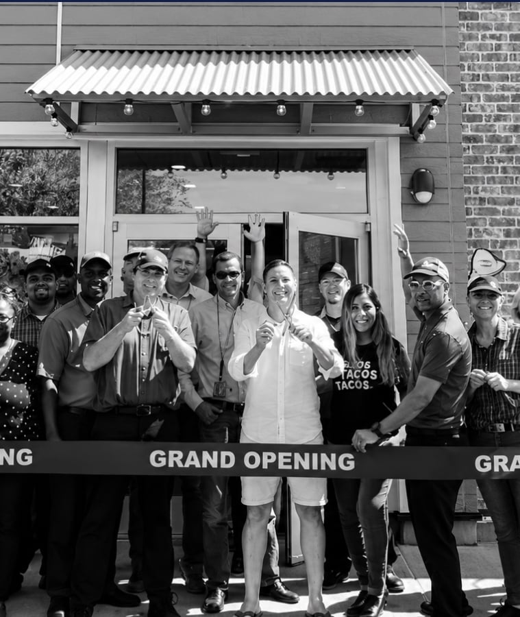 Team members celebrating at a restaurant grand opening ribbon cutting
