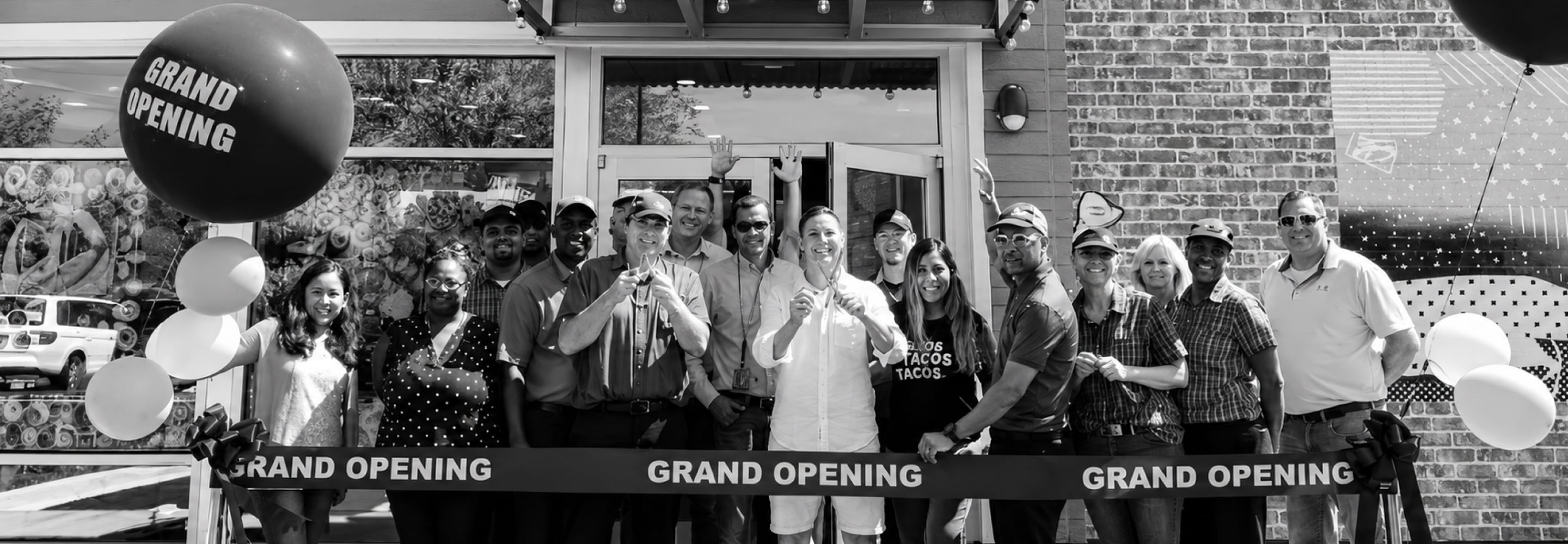 Team members celebrating at a restaurant grand opening ribbon cutting