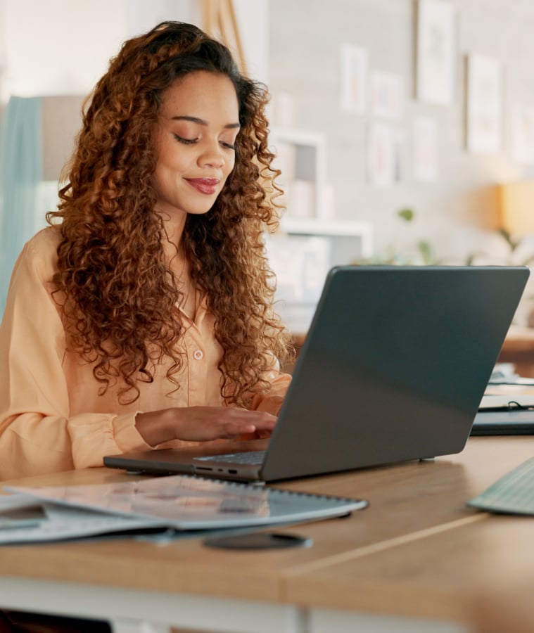 Woman working on a laptop in a bright creative office