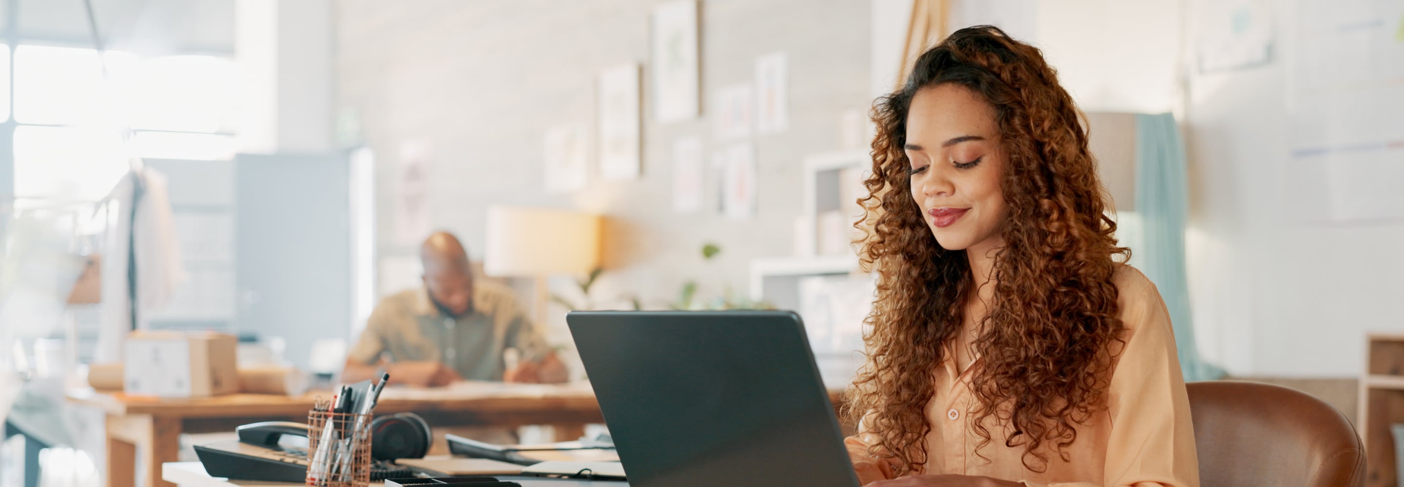 Woman working on a laptop in a bright creative office
