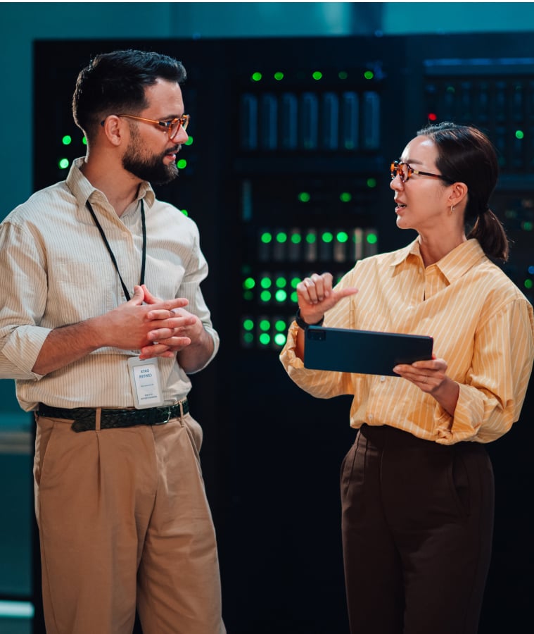 Two colleagues with a tablet talking in a data center