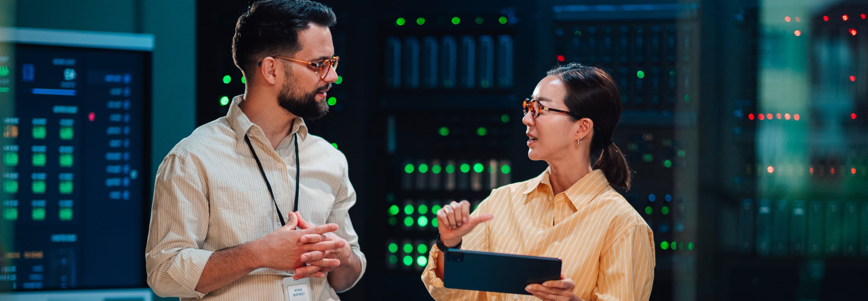 Two colleagues with a tablet talking in a data center