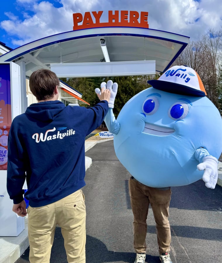 Child giving a high five to the Washville car wash mascot