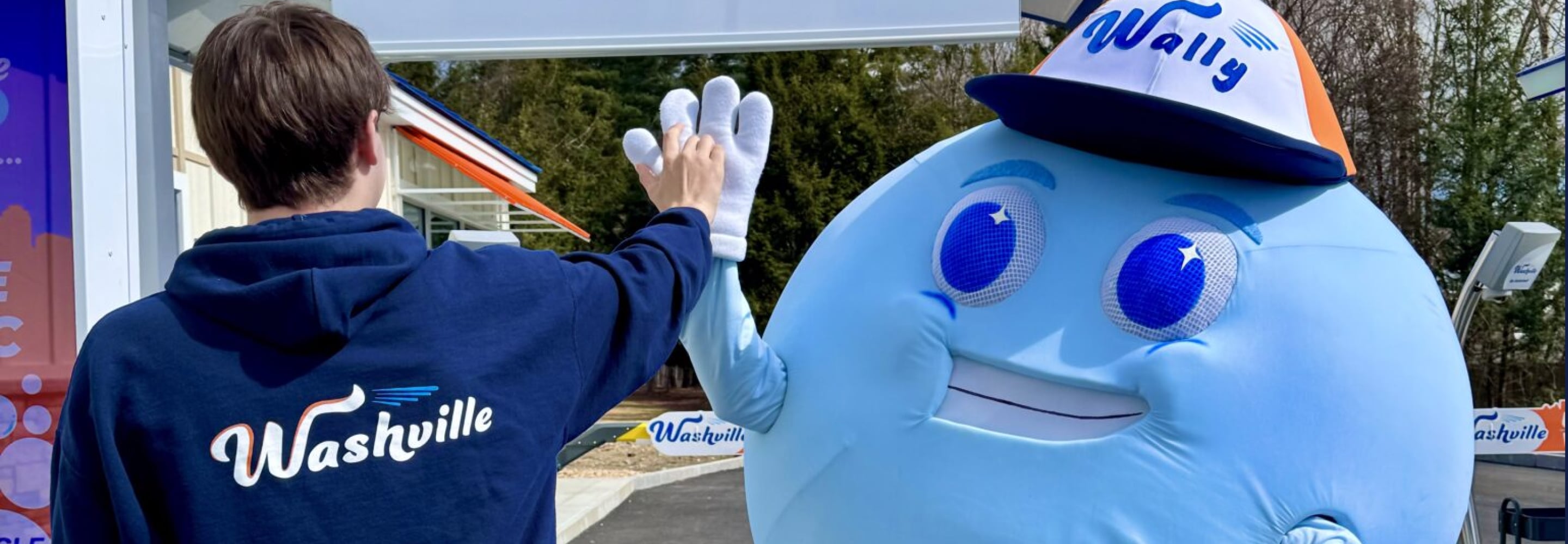 Child giving a high five to the Washville car wash mascot